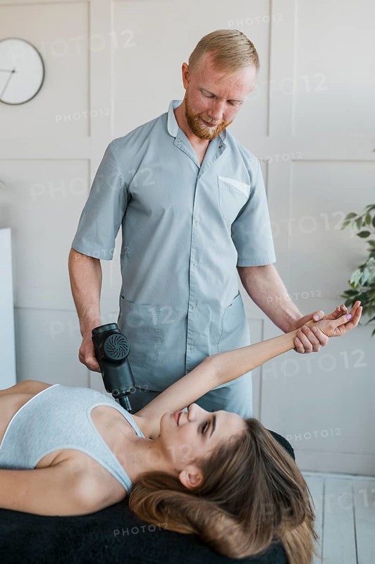 Male physiotherapist with female patient equipment during physical therapy session