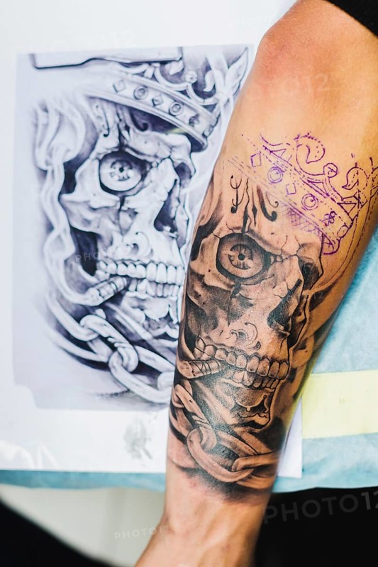 Arm with tattoo near sketch