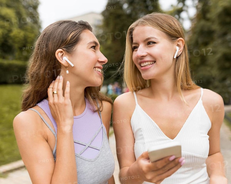 Girls wearing airpods park