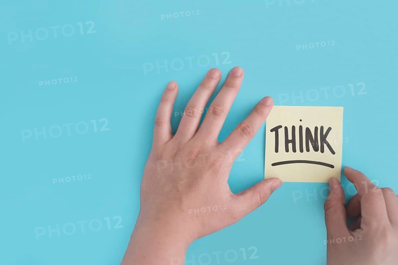 Hand sticking think adhesive note blue background