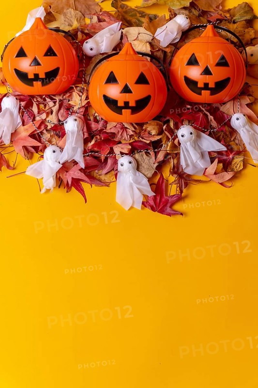 Overhead view of orange Halloween pumpkins on a background of yellow