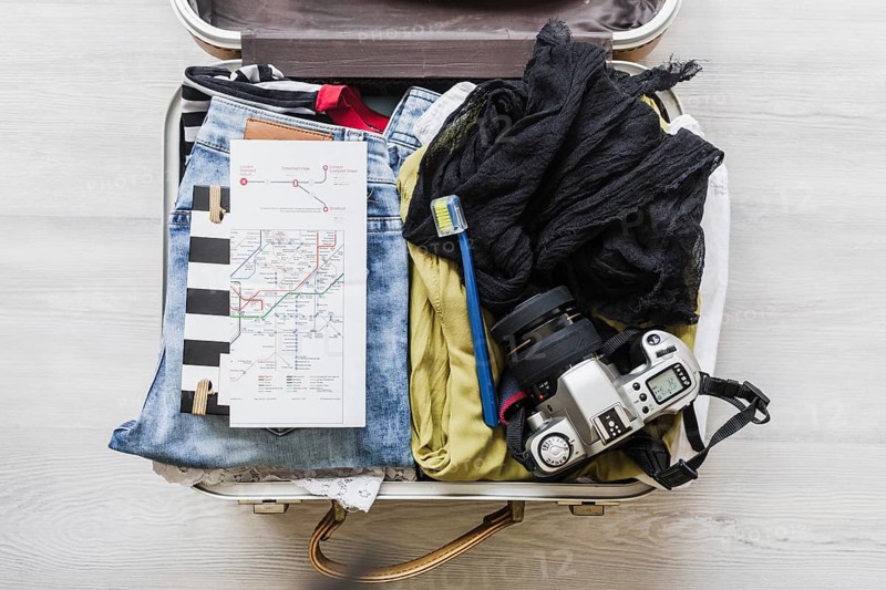 Top view female s travelling bag with camera brush map