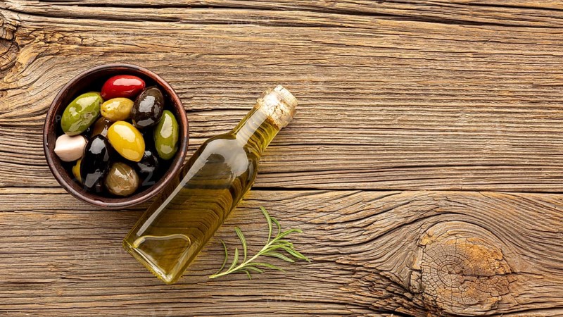 Assortment colorful olives with oil bottle copy space