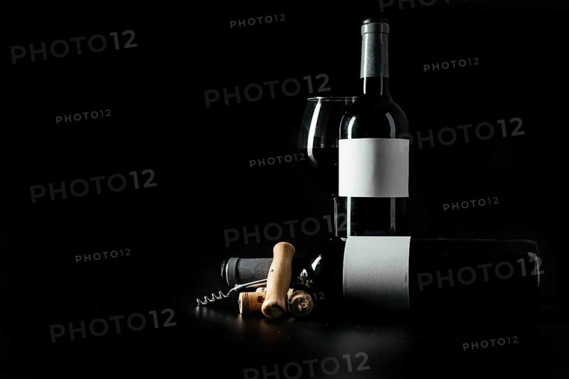 Corkscrew corks near bottles wineglass