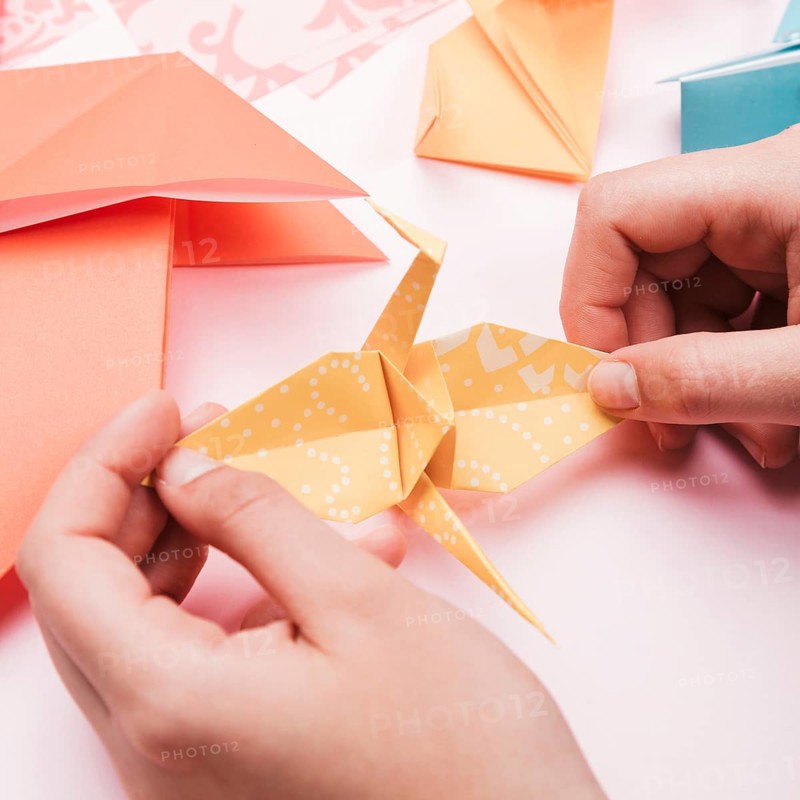High angle view artist hand holding origami paper bird