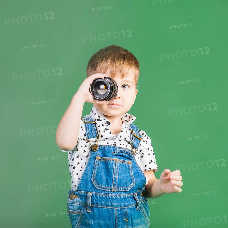 Boy holding camera lens eye