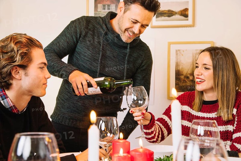 Man filling wine glass christmas dinner