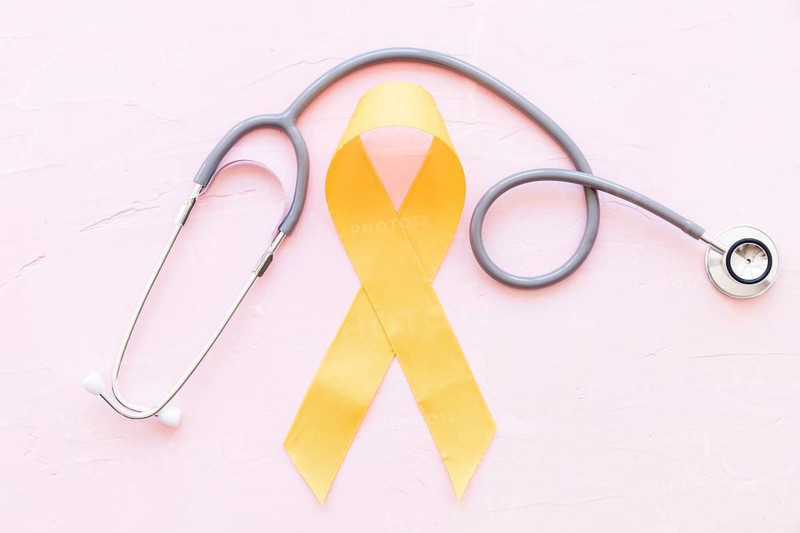Sarcoma bone cancer yellow ribbon with stethoscope pink background
