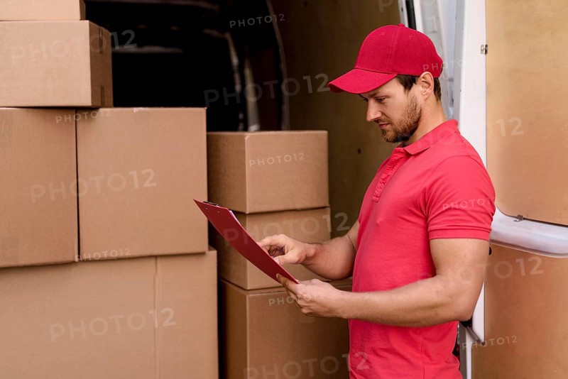 Side view delivery man checking packages list