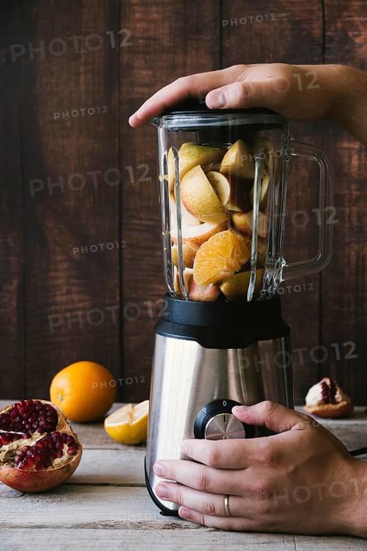 Blender with various fruit wooden background