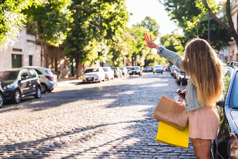 Woman with shopping bags catching taxi