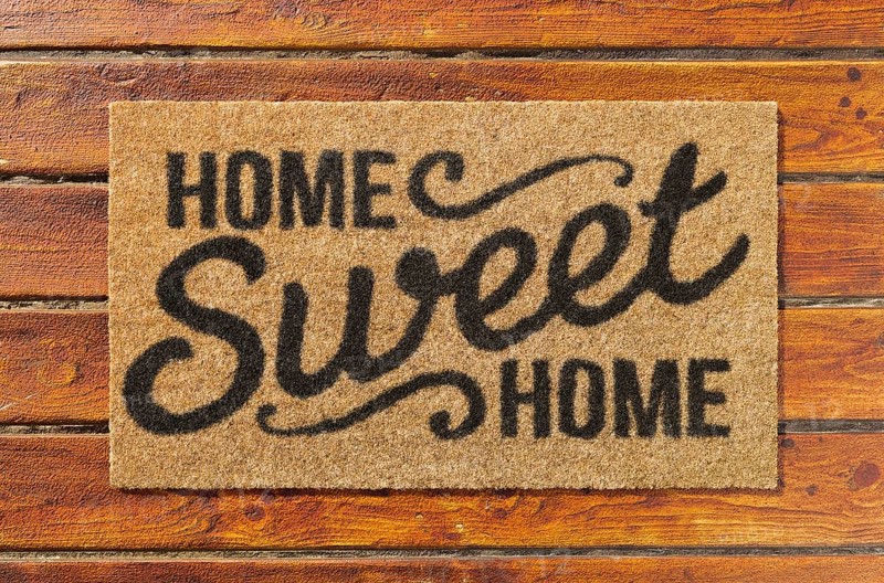 Overhead of home sweet home doormat on the wood plank porch