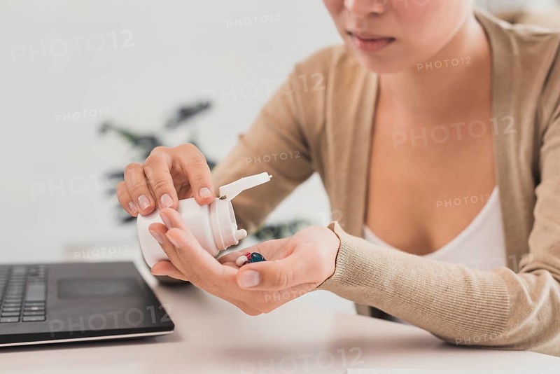 Close up woman taking pills office
