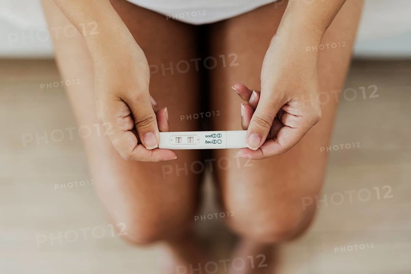Top view hands holding positive pregnancy test