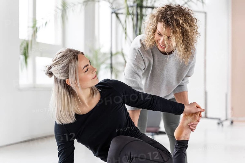 Woman doing yoga with teacher