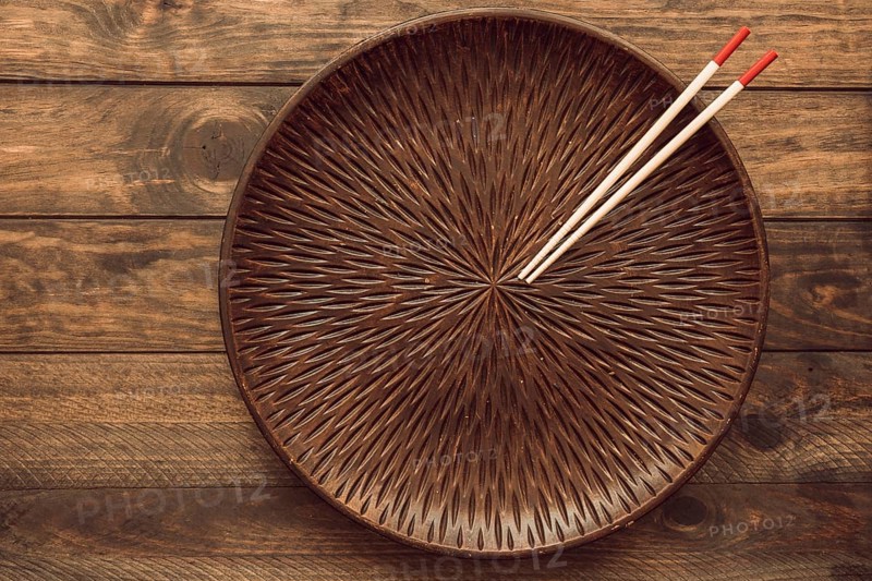 Empty round plate with two wooden chopsticks table