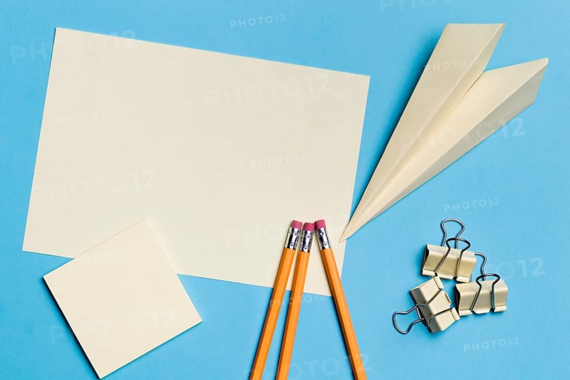 Top view paper plane with pencils desk