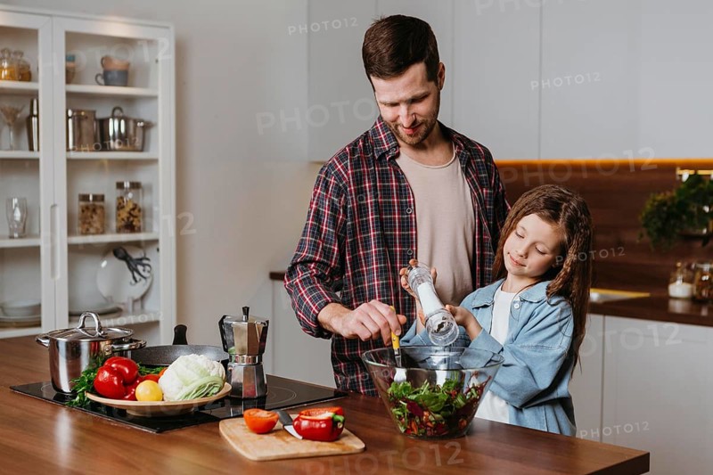 Front view father with daughter preparing food kitchen