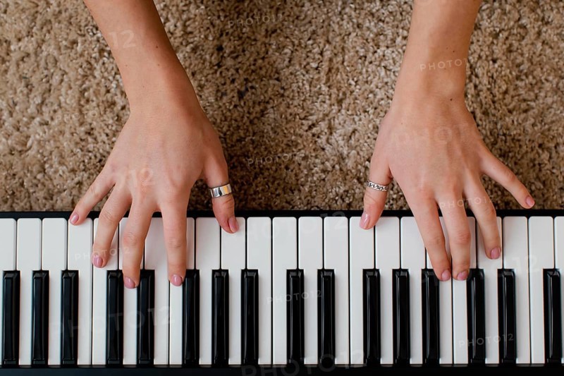 Top view female musician playing piano keyboard