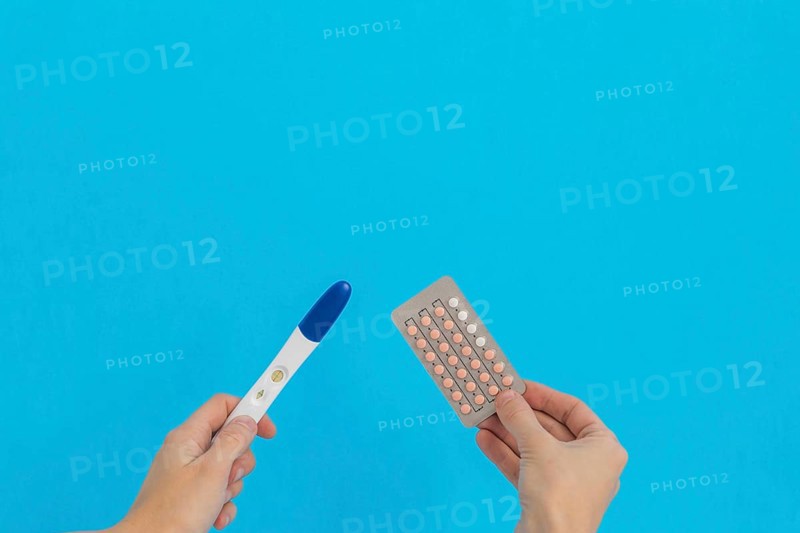 Hand holding contraceptive pills pregnancy test