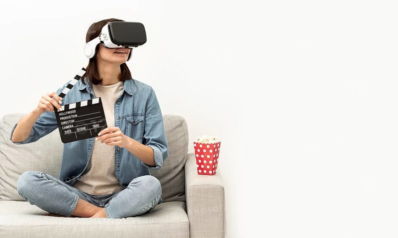 Portrait woman with virtual reality headset eating popcorn