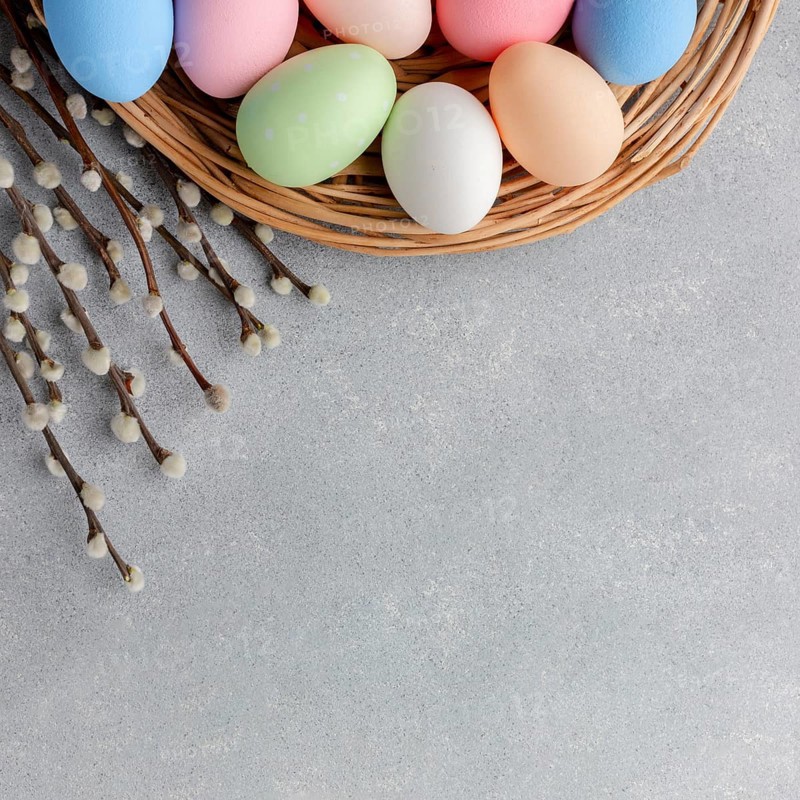 Top view colorful easter eggs basket with flowers copy space