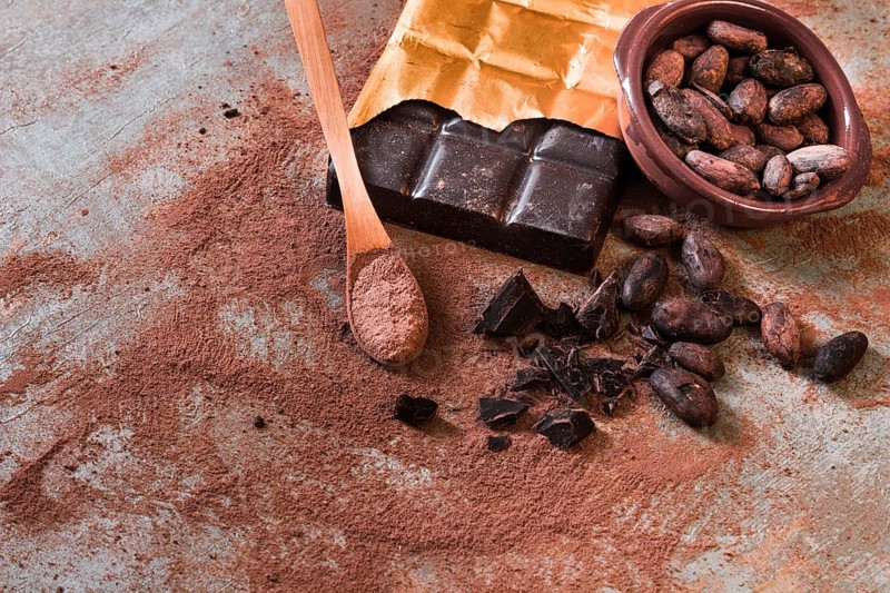 Crushed broken chocolate cocoa beans bowl rustic backdrop