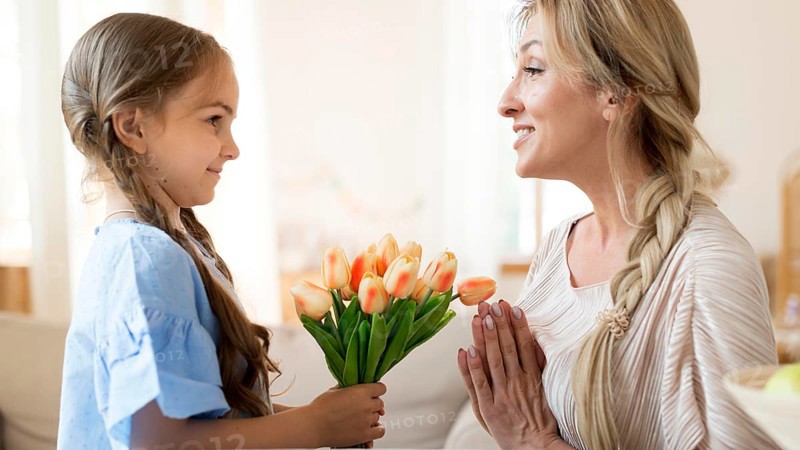 Daughter giving mother bouquet tulips as gift