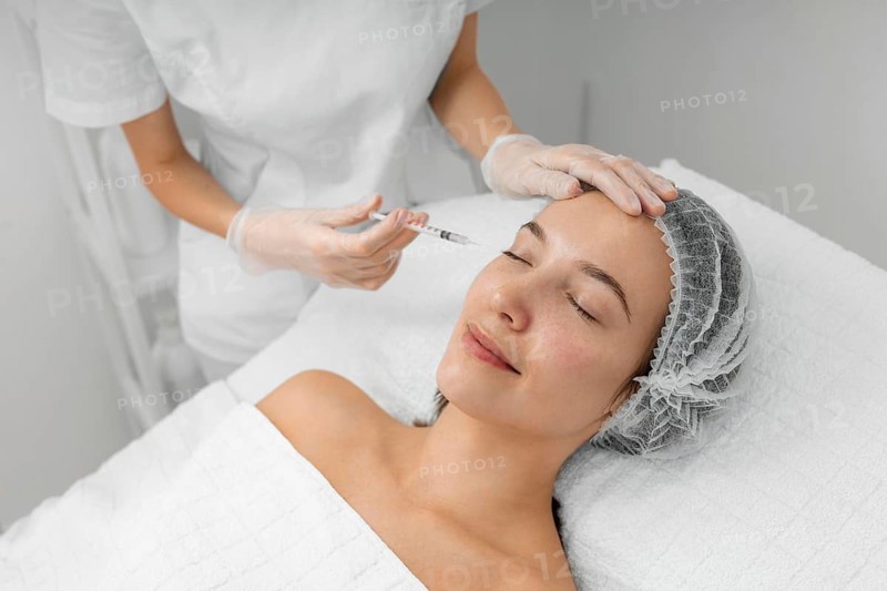 Beautician doing injection filler female client salon
