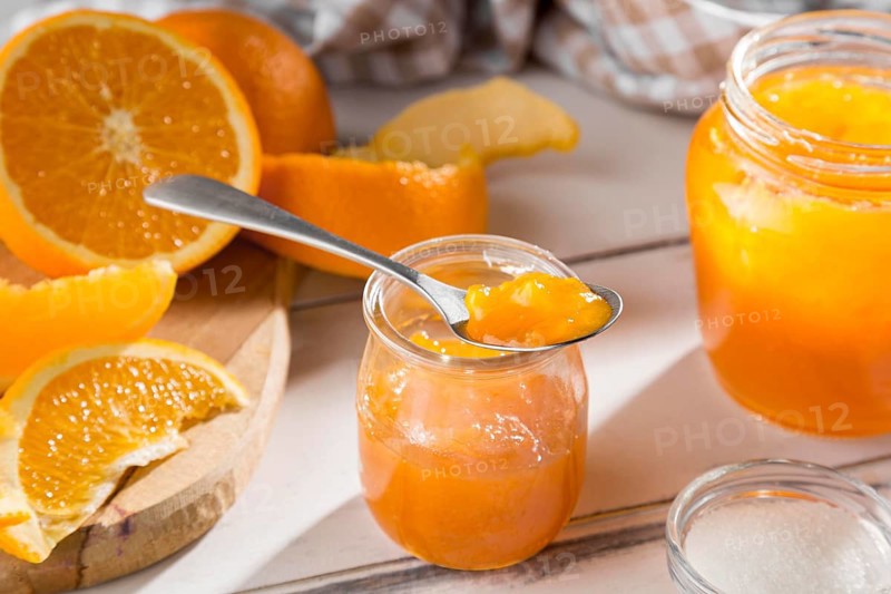 High angle clear glass jar with orange jam