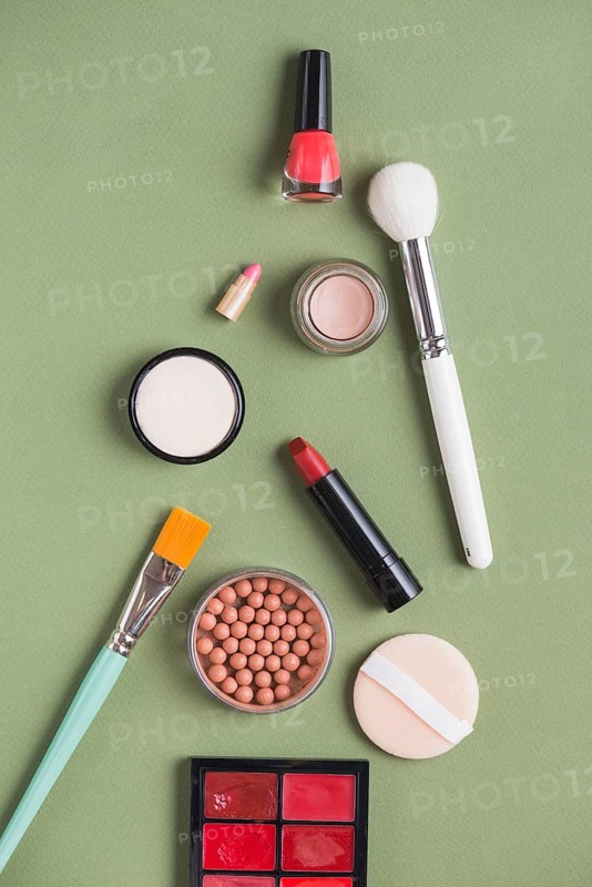 High angle view various makeup products green background