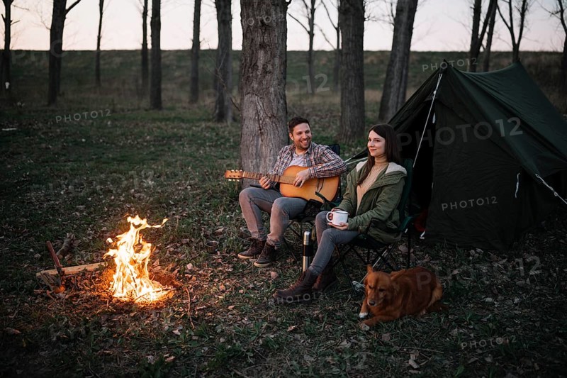 Full shot couple playing guitar