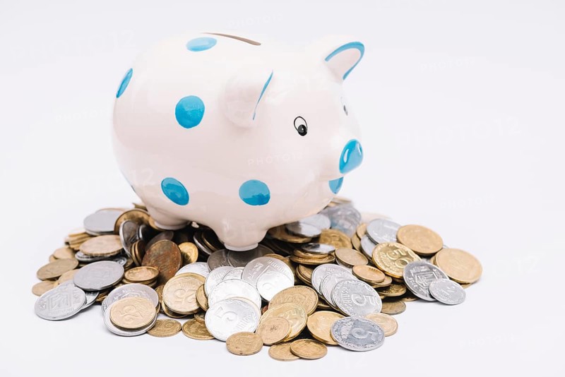 Piggybank many coins white background