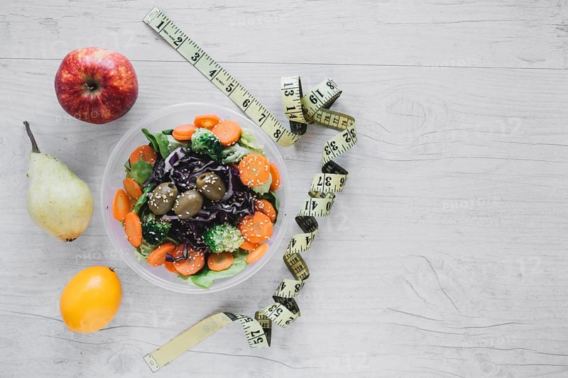Measuring tape near salad fruits