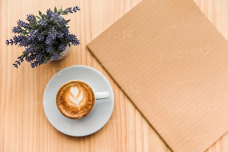 Coffee latte with lavender flower notebook wooden background