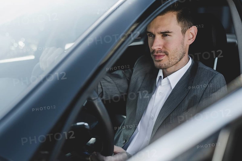 Close up young handsome businessman sitting car seat