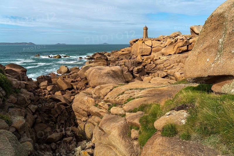 The rocks of the pink granite coast Cote de Granit Rose and the lighthouse Phare de Ploumanac'h near Ploumanac'h