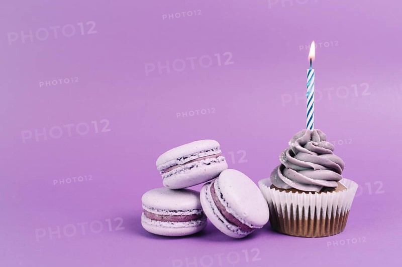 Macaroons near cupcake with candle