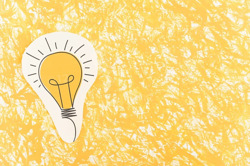 Hand drawn light bulb cut out yellow pattern background