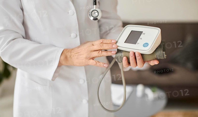 Elder covid recovery center female doctor holding blood pressure monitor