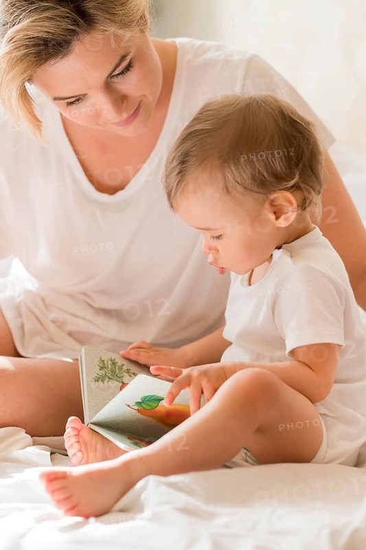 Portrait mom reading baby bed