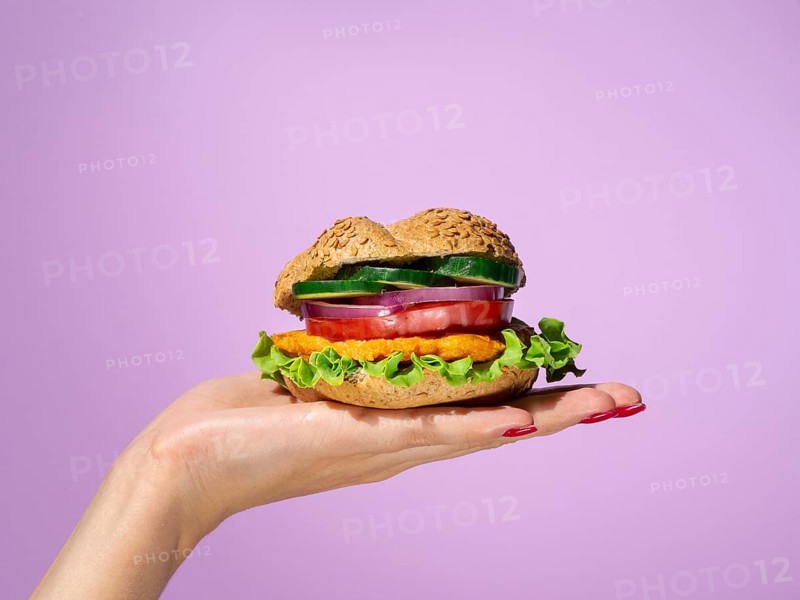Woman holding tasty burger her palm