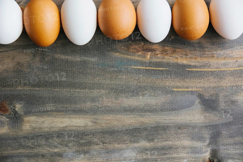 Row brown white eggs wooden background