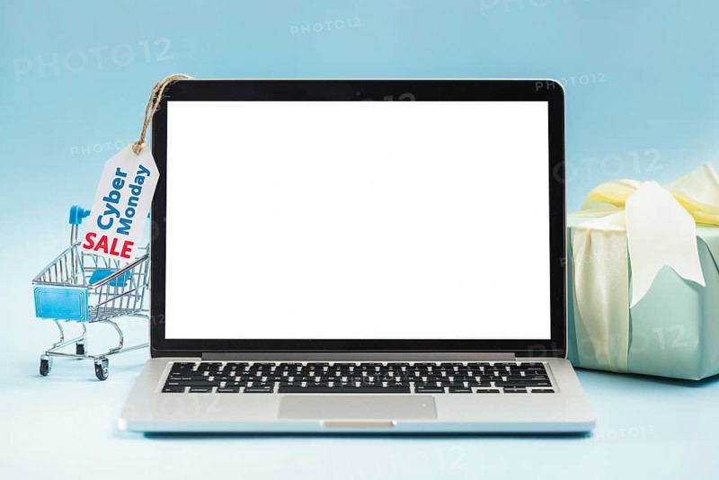 Laptop near shopping trolley tag gift box