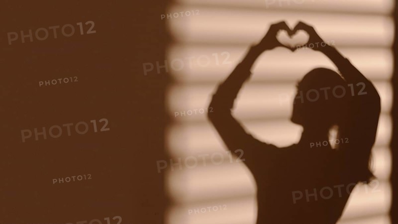Shadow woman making heart
