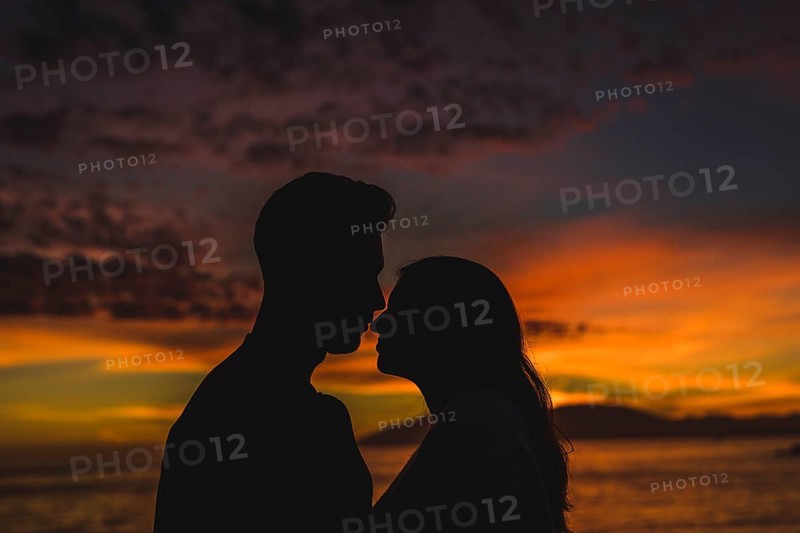 Young couple standing sea shore night