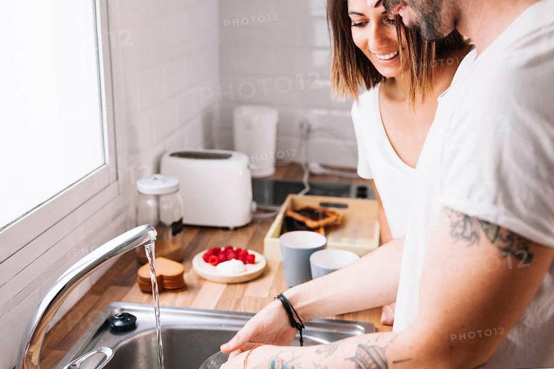 Couple washing dishes together