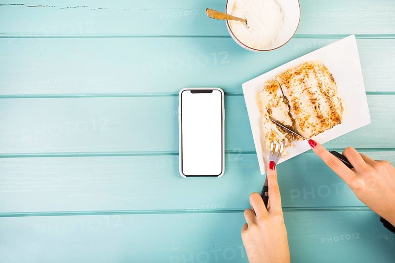 Elevated view woman s hand cutting lasagne