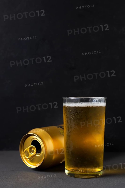 Front view beer can beside glass with beer