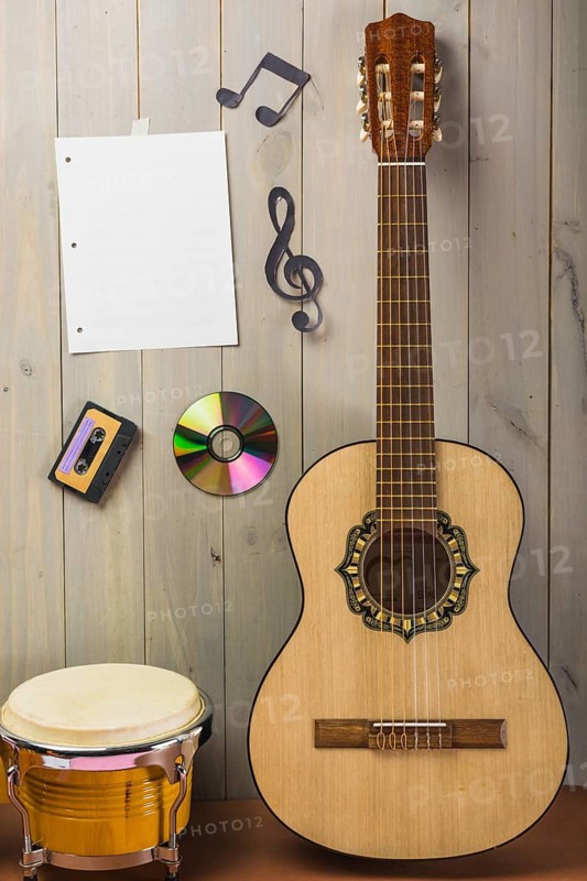 Blank musical page cassette compact disc musical note stuck wooden wall with guitar bongo drum